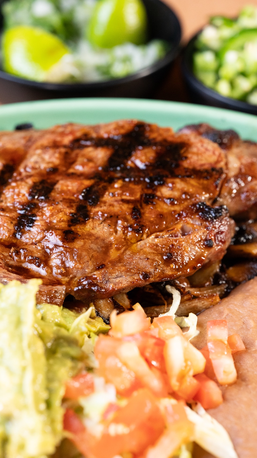 Char-broiled ribeye with guacamole, pico de gallo and refried beans